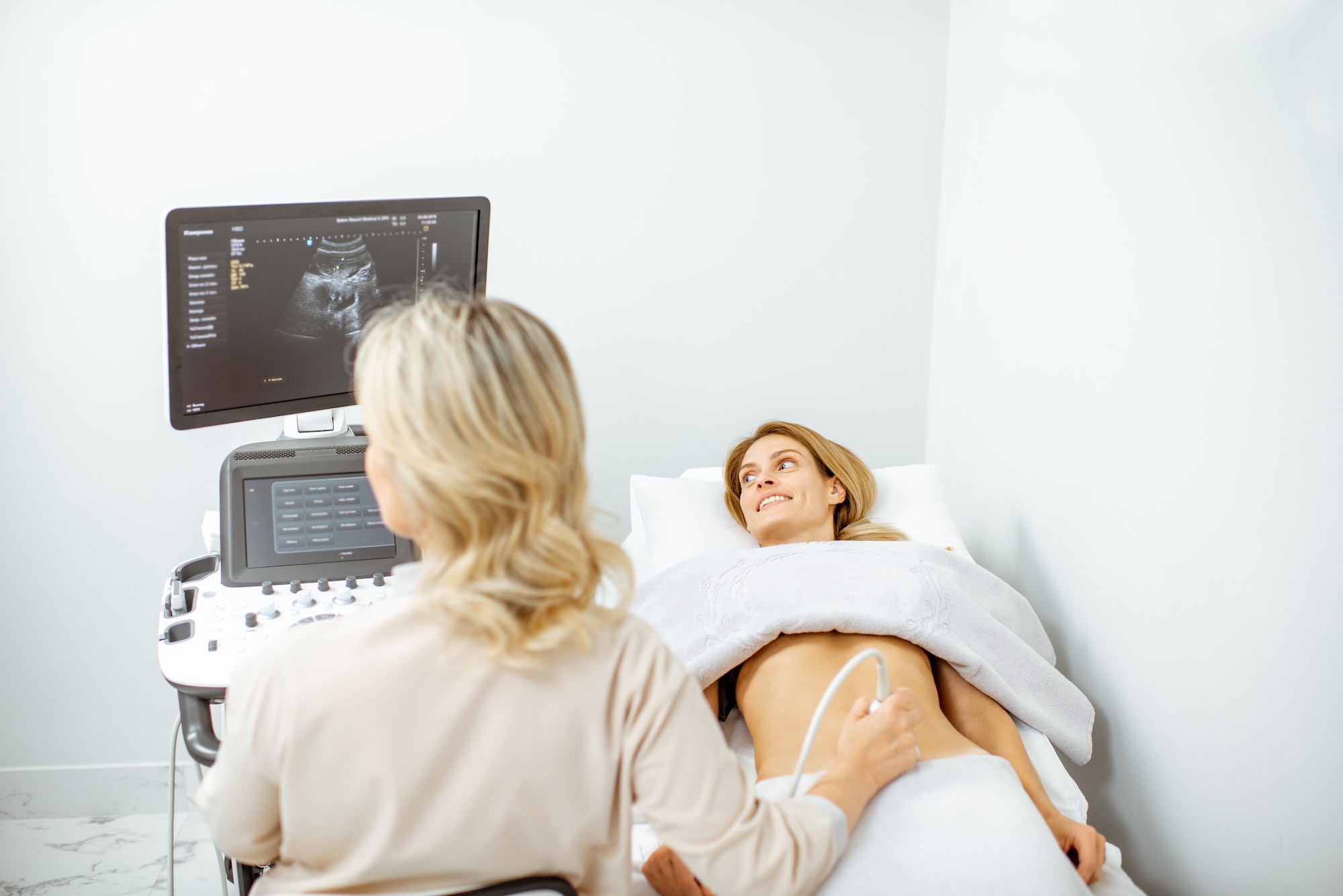 Doctor performs ultrasound examination of a woman